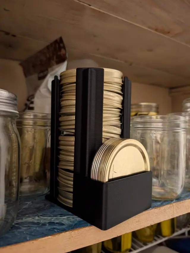 Black organizer holding a stack of gold mason jar lids