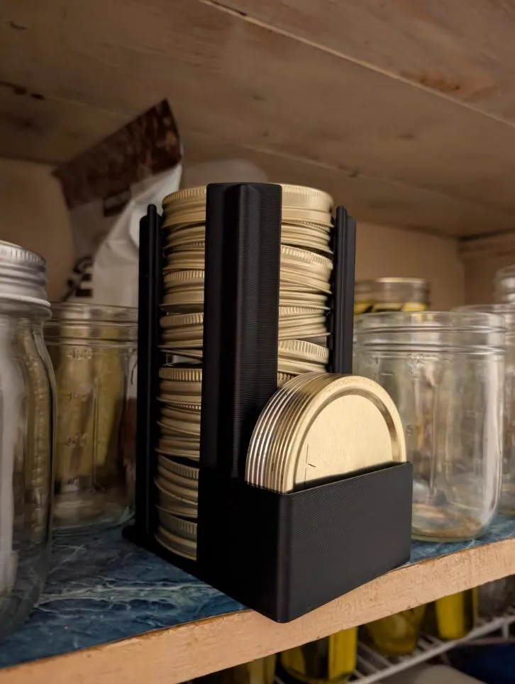Black organizer holding a stack of gold mason jar lids