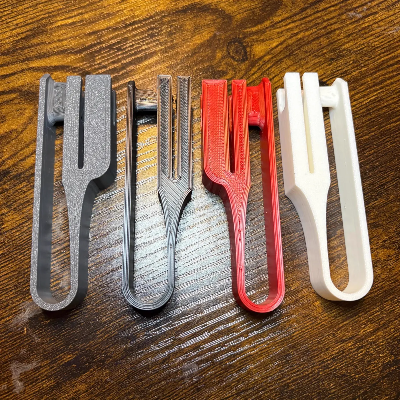 Four printed clips in grey, dark grey, red and white