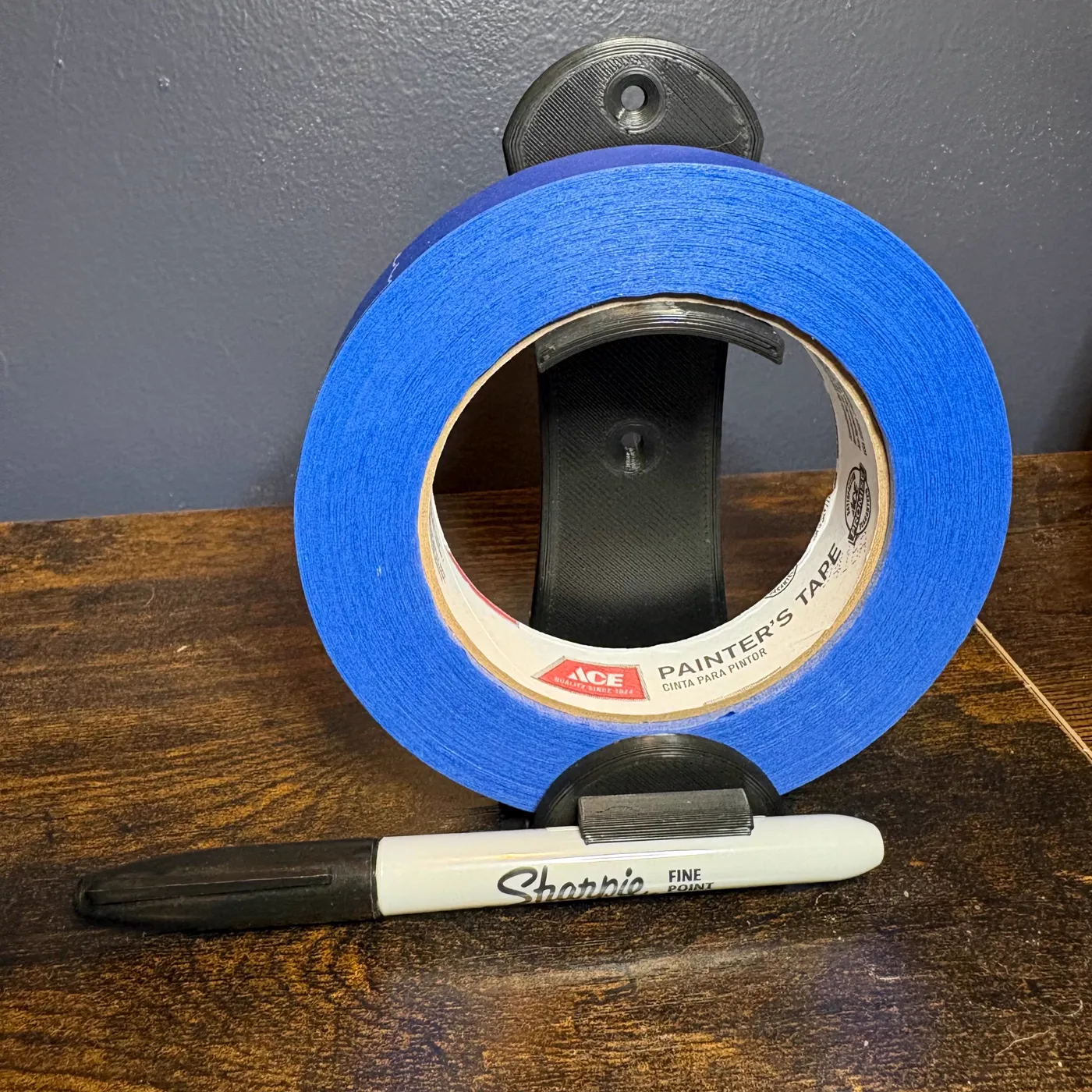 Wall mounted painter's tape holder with a marker